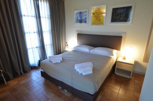 a bedroom with a large bed with two towels on it at Villa Nadar in Altopascio