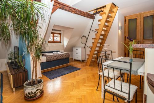 a living room with a bed and a staircase at Ubytování u BÍLÉ PANÍ in Český Krumlov