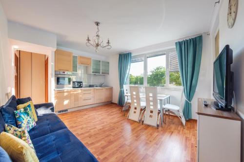 un soggiorno con divano blu e una cucina di Apartamenty Sun & Snow Sikorskiego a Kołobrzeg