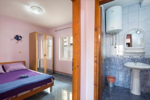 a bedroom with a bed and a shower and a sink at Apartments Antic in Budva
