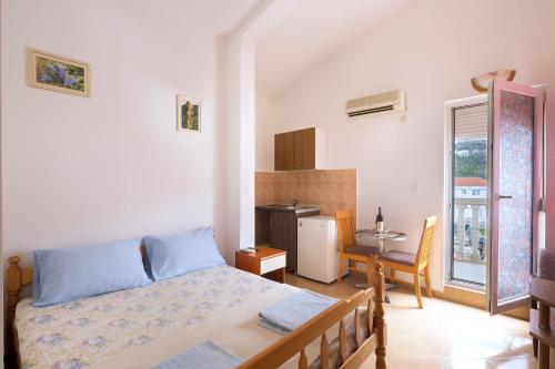 a bedroom with a bed and a table and a kitchen at Apartments Antic in Budva