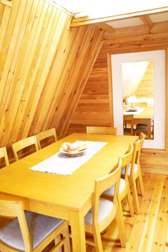 a wooden dining room with a wooden table and chairs at DOM LAS - natura, relaks, jacuzzi. in Mianów