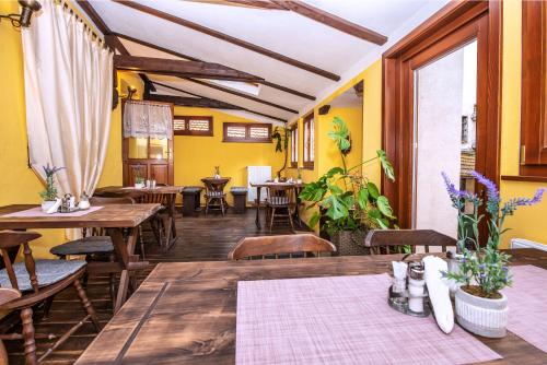 チェスキー・クルムロフにあるUbytování u BÍLÉ PANÍの木製のテーブルと椅子、黄色の壁が特徴のレストラン