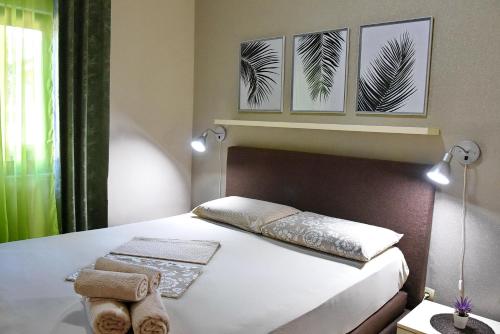 een slaapkamer met een bed met drie foto's aan de muur bij Apartmani Ćetković in Kotor