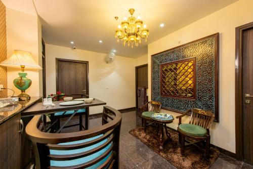 comedor con mesa, sillas y lámpara de araña en House of Backpackers en Jaipur