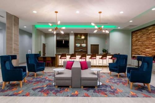 a lobby with a waiting room with a table and chairs at La Quinta by Wyndham Altoona Des Moines in Altoona