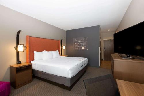 a hotel room with a bed and a flat screen tv at La Quinta by Wyndham Altoona Des Moines in Altoona