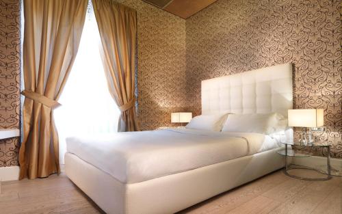 a bedroom with a white bed and a window at LE RÊVE DE NAIM Roma in Rome