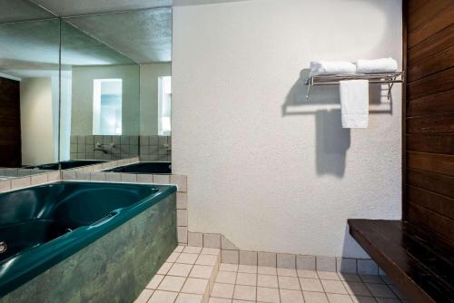 a bathroom with a large tub and a mirror at La Quinta Inn by Wyndham Bend in Bend