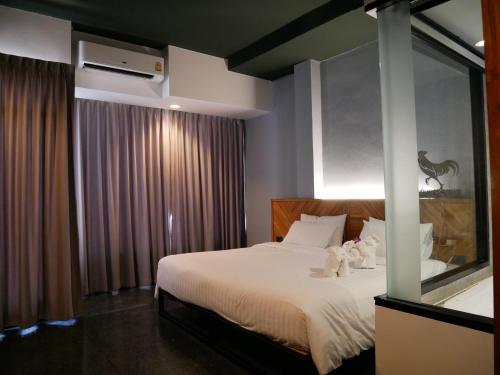 a bedroom with a large bed and a window at OU HOTEL in Phitsanulok