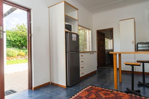 a kitchen with a refrigerator and a table at Melkboomsdrift Guest House & Conference Centre in Vredendal