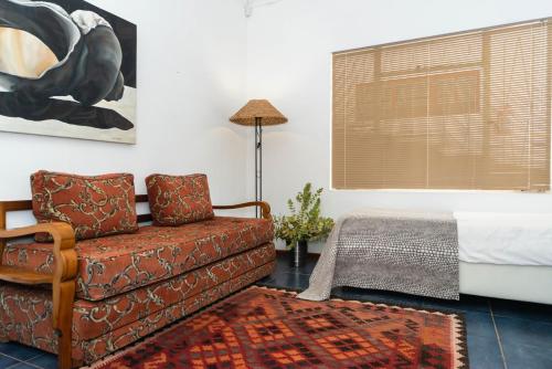 a bedroom with a couch and a bed and a window at Melkboomsdrift Guest House & Conference Centre in Vredendal