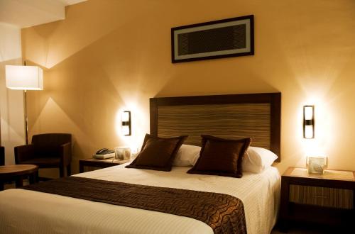 a hotel room with a bed and a chair at Hotel Felda Residence Kuala Terengganu in Kuala Terengganu