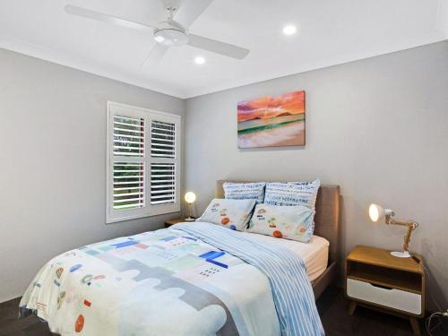 a small bedroom with a bed and a window at Bay Parklands 33 Air conditioning Foxtel Pool Tennis Court andSpa in Shoal Bay