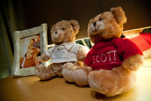 two teddy bears sitting on a table next to a mirror at Ascott Raffles City Beijing in Beijing