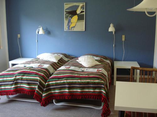 a bedroom with a bed with a blanket on it at Djurs-BnB - Rimsøhuset in Rimsø