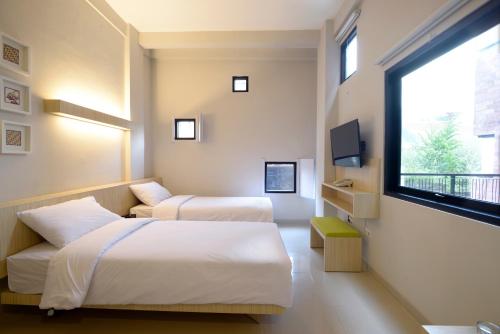 a hotel room with two beds and a window at Arjuna Hotel Batu City in Batu