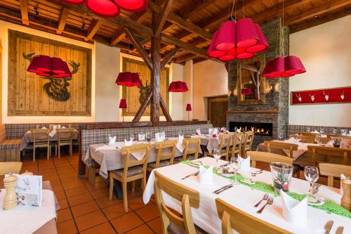a restaurant with tables and chairs and red chandeliers at Hotel Hirsch in Neu Ulm