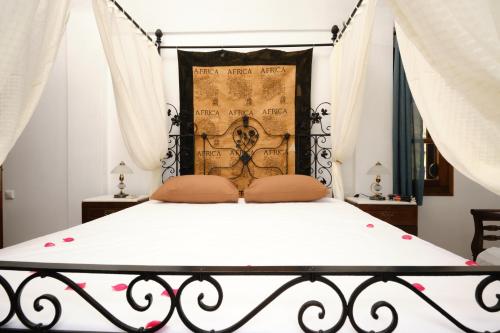 een slaapkamer met een bed met een smeedijzeren bedframe bij Private Villa Evgenia with swimming pool in Perissa