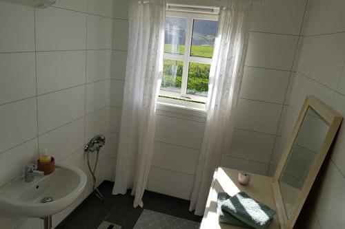 a white bathroom with a sink and a window at Lofoten- Enjoy the Nature-With a beautiful beach in Napp