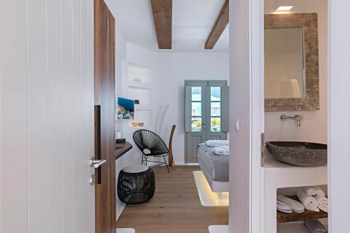 uma casa de banho com um lavatório e uma cama num quarto em 3 Elements by Stylish Stays em Oia