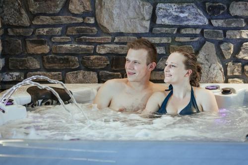 a man and a woman in a hot tub at Ferienhof A&B Wellness Villa 6 personen in Bullange