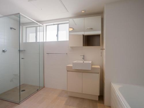 uma casa de banho com uma cabina de duche em vidro e um lavatório. em Cote D'Azure, 13 61 Donald Street - Lovely unit air con, Wi-Fi, secure parking, complex lift and pool em Nelson Bay