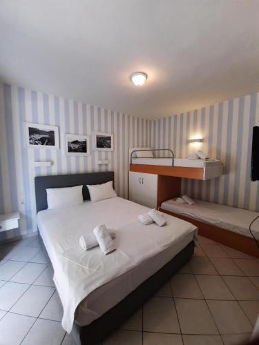 a bedroom with two beds and a bunk bed at Aliki Studios in Parga