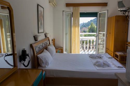 a bedroom with a bed with a view of a balcony at Aliki Studios in Parga