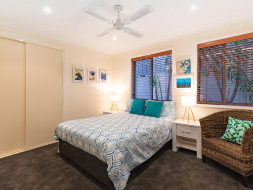 a bedroom with a bed and a chair at Dutchies Vista, 1 45 Christmas Bush Ave - Ground floor duplex with stunning water views and close to the beach in Nelson Bay