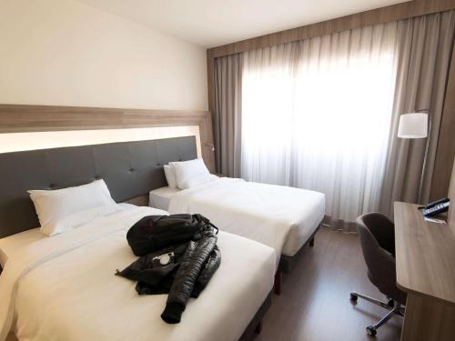a hotel room with two beds with a backpack on them at Novotel São Paulo Berrini in Sao Paulo