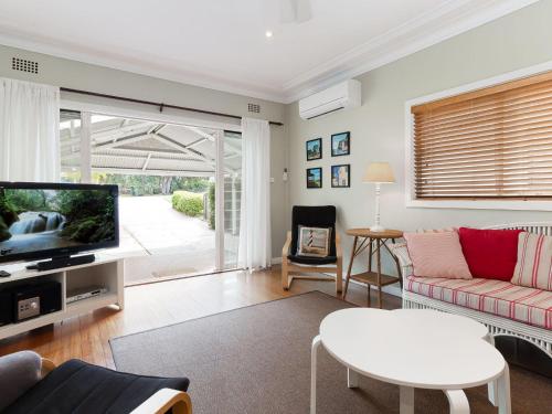 a living room with a couch and a tv at Dutchies Haven, 11 Christmas Bush Ave - Pet friendly, large enclosed yard, air con and Wi-Fi in Nelson Bay