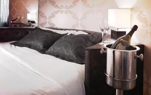 a bottle of wine in a bucket next to a bed at LE RÊVE DE NAIM Roma in Rome