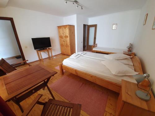 een slaapkamer met een bed, een tafel en een televisie bij Casa Terezia in Braşov