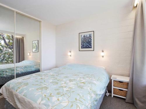 Schlafzimmer mit einem Bett und einem Spiegel in der Unterkunft Far Horizons 3 cosy comfortable unit with filtered views in Shoal Bay