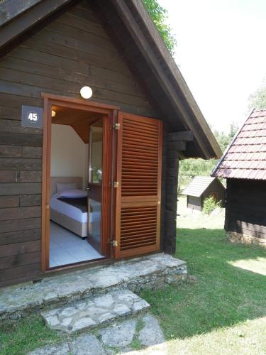 a small cabin with a bed inside of it at Bungalows Korana - Campsite Korana in Seliste Dreznicko