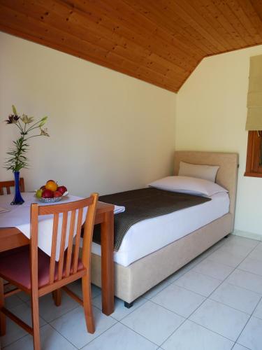Un dormitorio con una cama y una mesa con un bol de fruta en Bungalows Korana - Campsite Korana, en Selište Drežničko