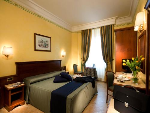 a hotel room with a bed and a desk at Hotel Sonya in Rome