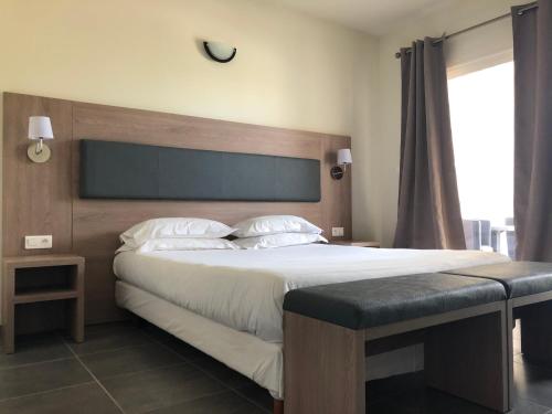 a bedroom with a large bed and a large window at Bella Vista Hôtel, Suites & Maisons in Porticcio