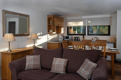 a living room with a couch and a kitchen at Moness Resort in Aberfeldy
