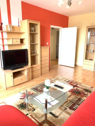 a living room with a glass table and a tv at Apartment Botanika2 in Trnava
