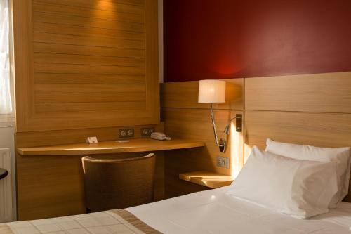 a hotel room with a bed and a desk at Best Western Plus Le Lavarin in Avignon
