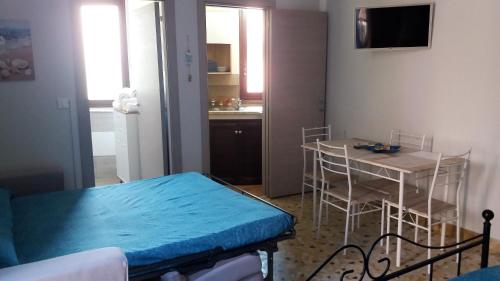 um pequeno quarto com uma mesa e uma cozinha em Casa Vacanza Trappeto Palermo em Trappeto