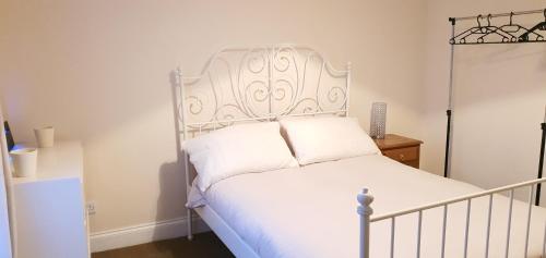 a bed with a white headboard in a bedroom at Grace Apartments - Living Waters 2 in Ashford