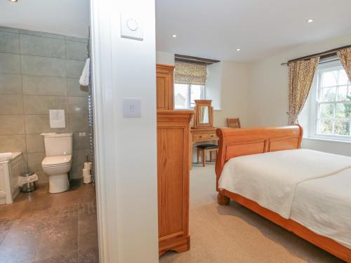 a bedroom with a bed and a bathroom at Oak Tree Cottage in Coniston