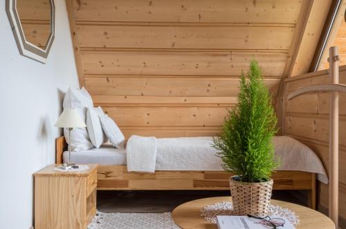 a bedroom with a bed with a plant on a table at Domek Odlotowy Zakatek in Kościelisko