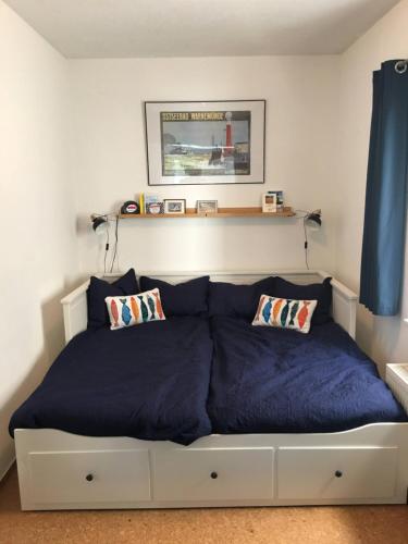 a bedroom with a bed with blue sheets and pillows at FeWo Seagull in Warnemünde