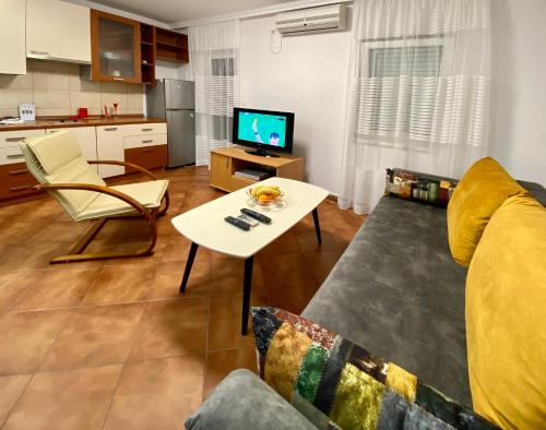 uma sala de estar com um sofá e uma mesa em Family Beachfront Apartment em Petrovac na Moru