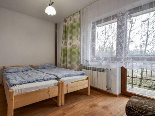 une chambre avec un lit et une grande fenêtre dans l'établissement Helena Gał, à Białka Tatrzańska
