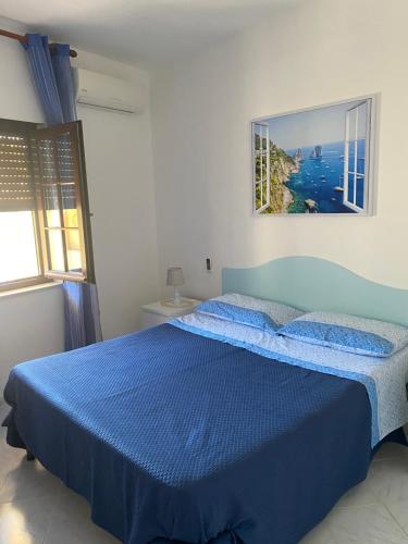 um quarto com uma cama azul e uma colcha azul em Bambiniello em Anacapri